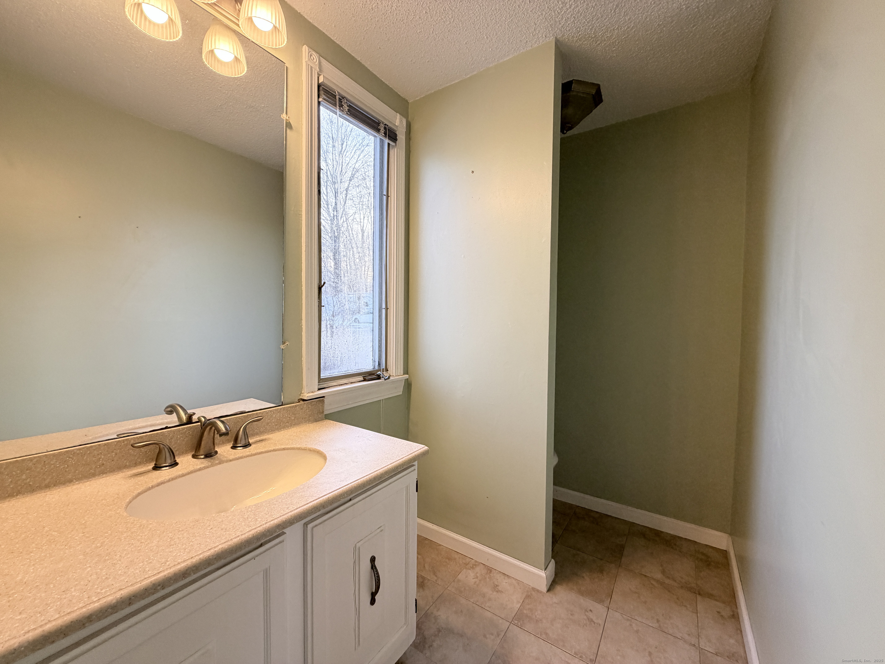 105 Spring Lane, Unit 105 Suffield, CT 06078 - Photo 6 of 16 a bathroom with a sink and a mirror