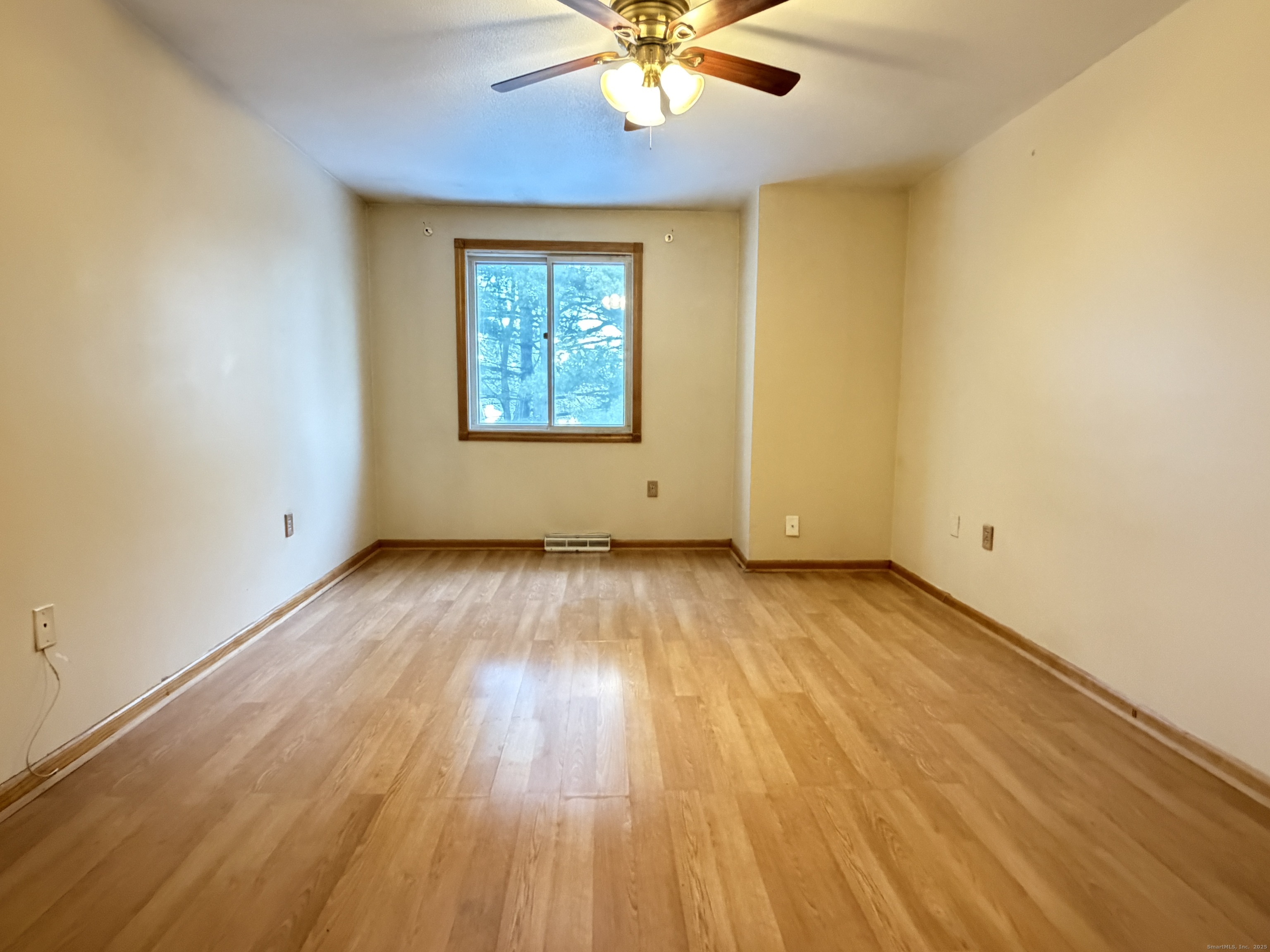 105 Spring Lane, Unit 105 Suffield, CT 06078 - Photo 7 of 16 an empty room with wooden floor chandelier fan and windows