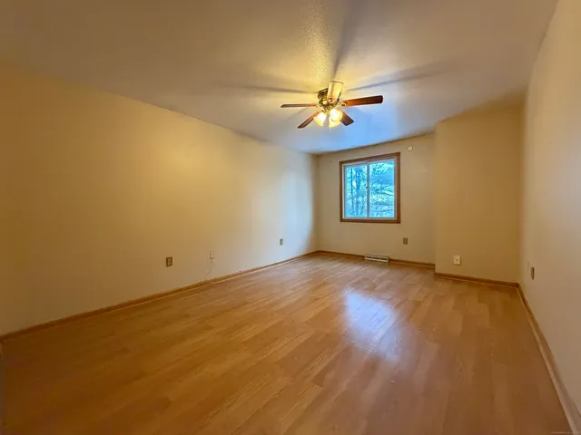 an empty room with windows and fan
