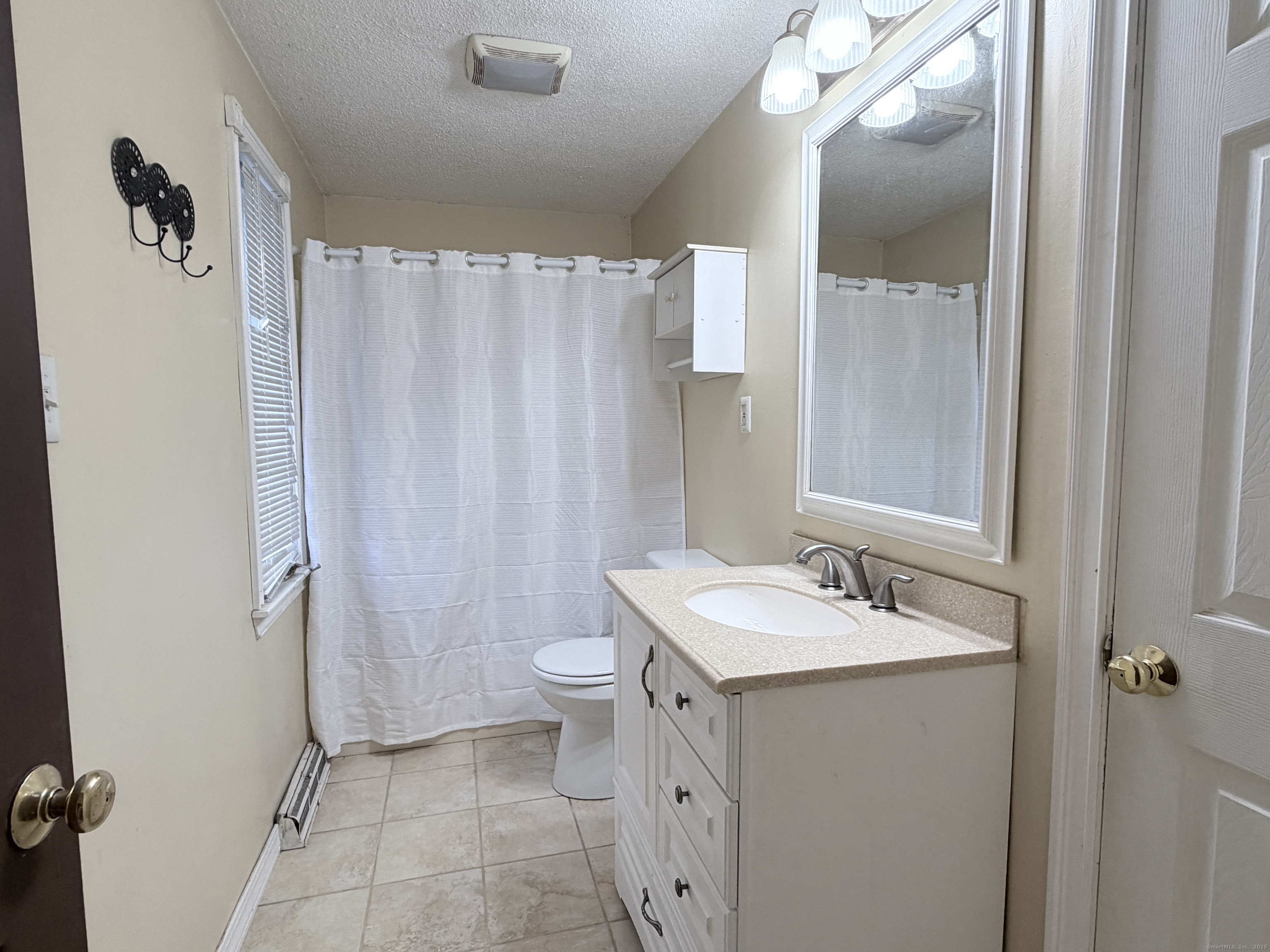 105 Spring Lane, Unit 105 Suffield, CT 06078 - Photo 9 of 16 a bathroom with a sink a toilet and shower