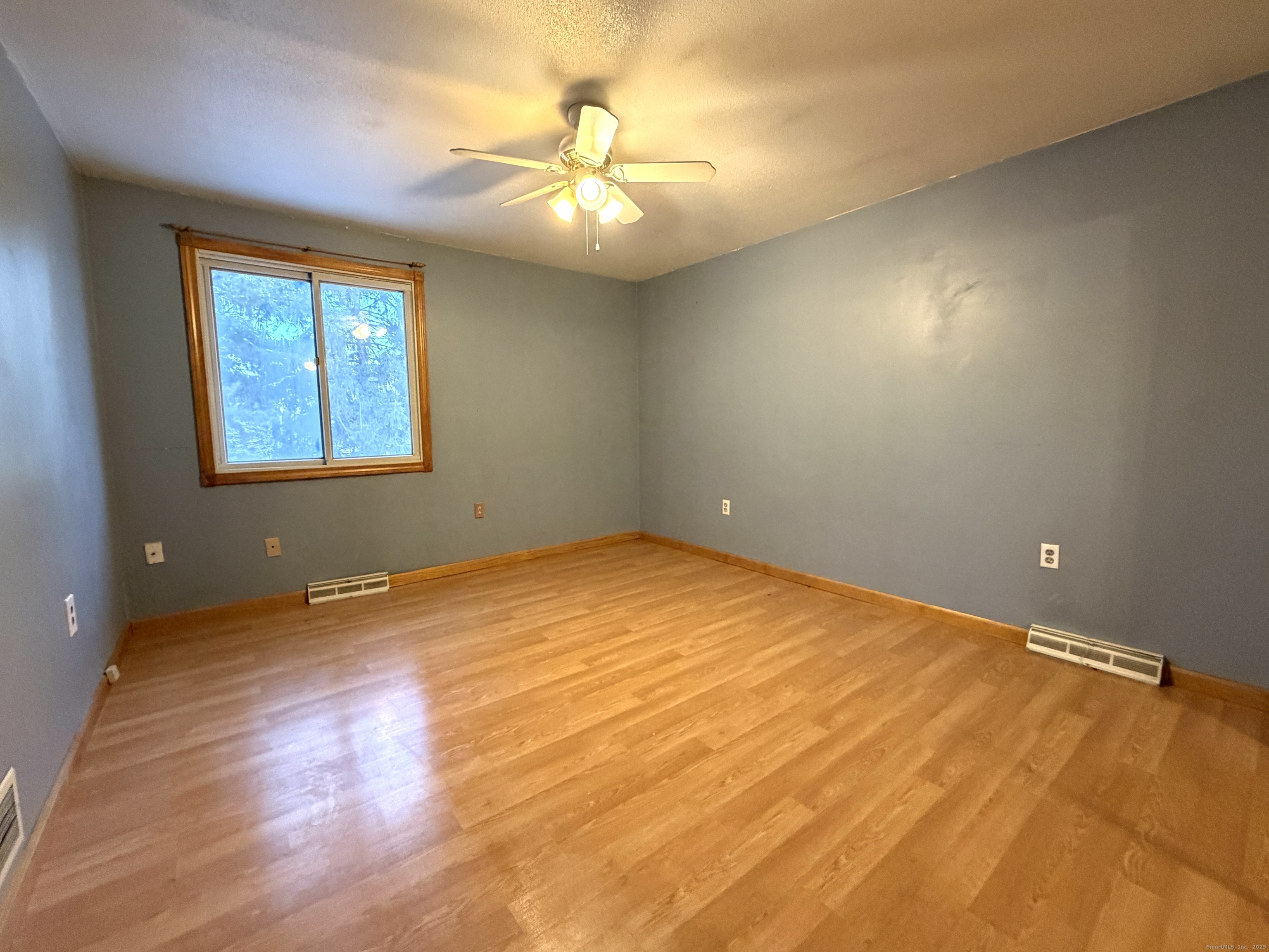 105 Spring Lane, Unit 105 Suffield, CT 06078 - Photo 10 of 16 an empty room with a chandelier fan and windows