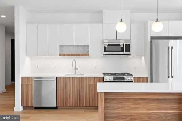 a kitchen with cabinets and wooden floor