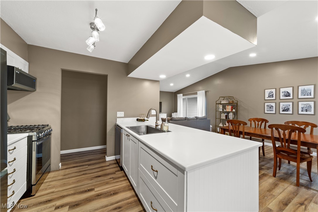 2977 Reeves Road Willoughby, OH 44094 - Photo 11 of 49 Kitchen with light LVP flooring, stainless steel appliances, a peninsula, and a sink