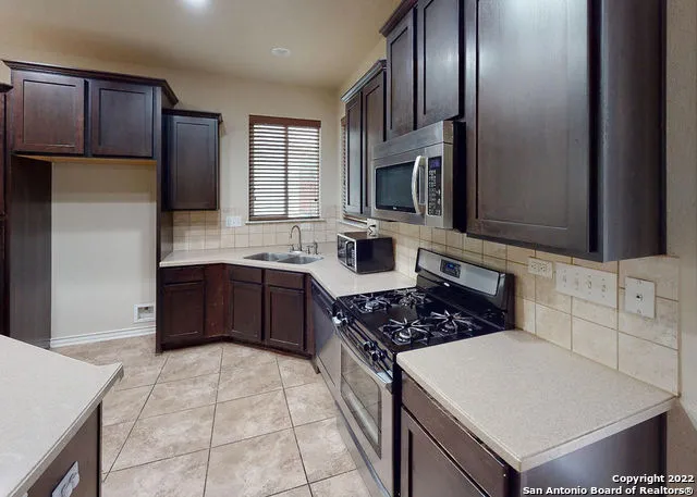 a kitchen with stainless steel appliances a sink stove and refrigerator