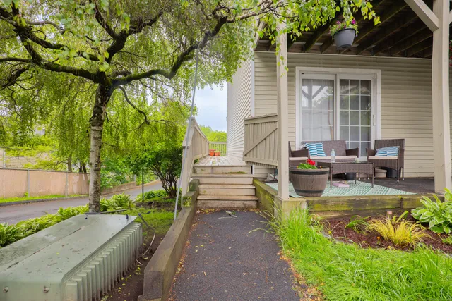 a view of a patio with table and chairs potted plants and large tree