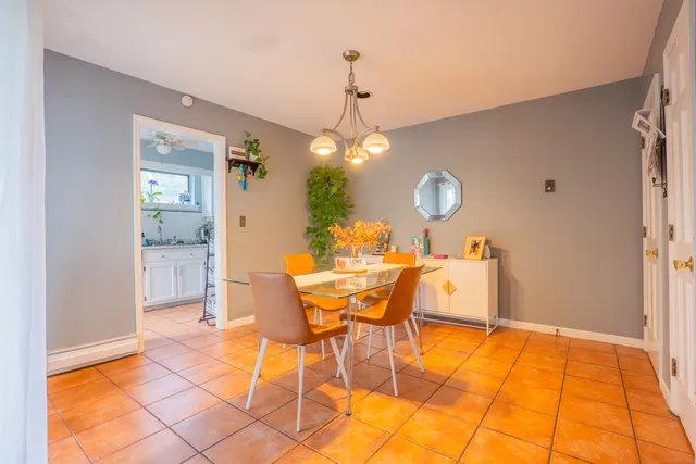 a dining room with chandelier and wooden floor