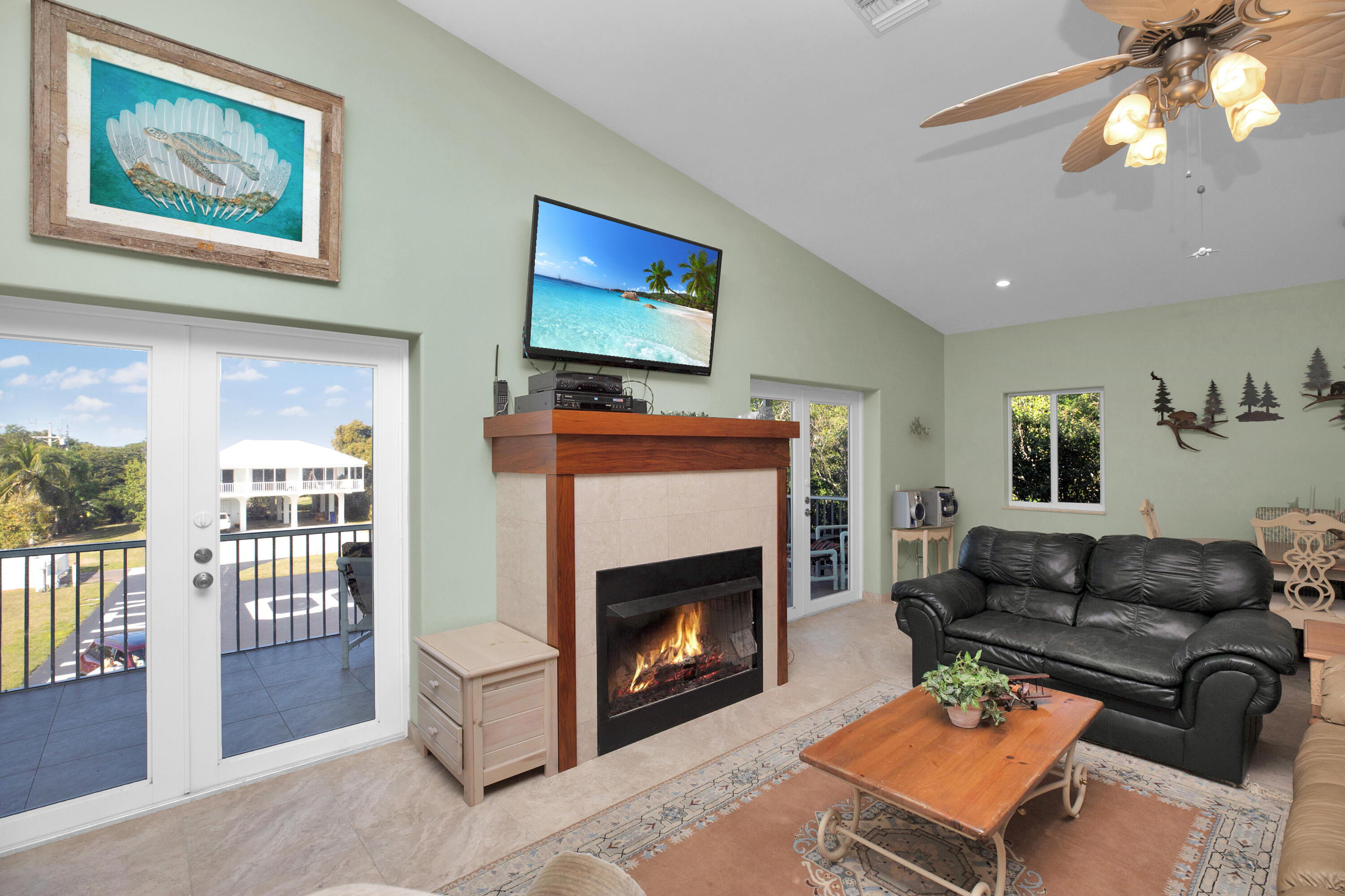 100 South Airport Road Tavernier, FL 33070 - Photo 11 of 42 a living room with furniture a flat screen tv and a fireplace