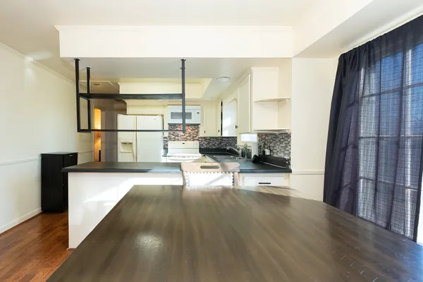 a kitchen with granite countertop a sink cabinets and stainless steel appliances