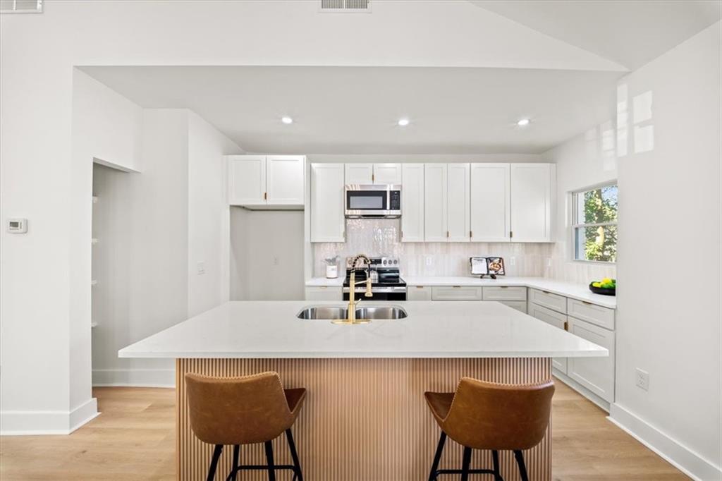 1523 Melrose Drive Southwest Atlanta, GA 30310 - Photo 10 of 33 a kitchen with stainless steel appliances a sink a stove a refrigerator counter top space and cabinets