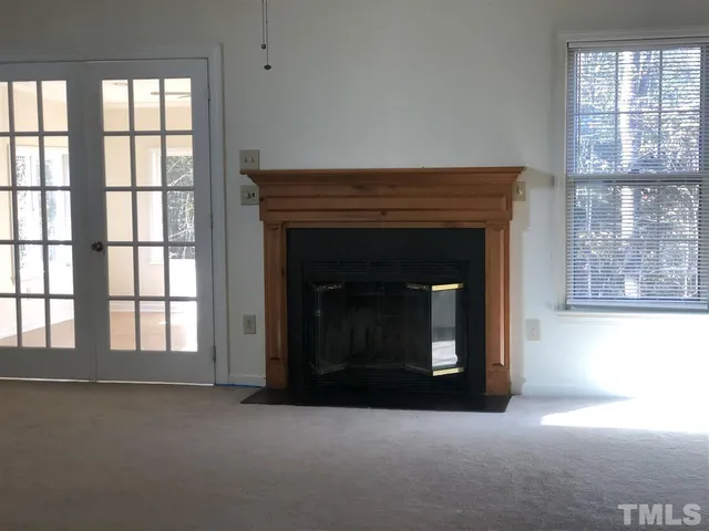 a living room with a fireplace and windows
