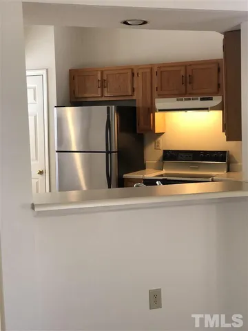 a view of kitchen with a refrigerator and window
