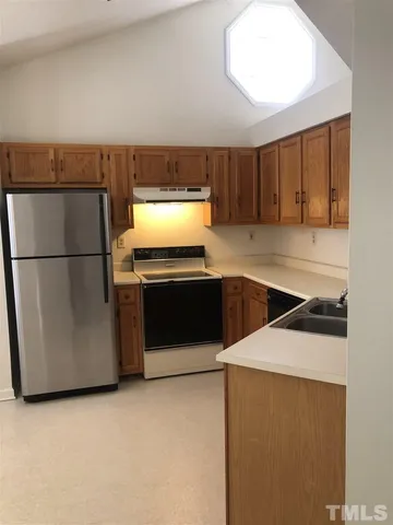 a kitchen with a stove a refrigerator and a sink
