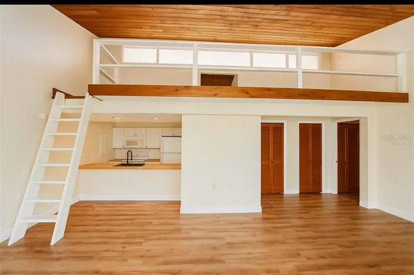 a view of a living room with furniture and wooden floor