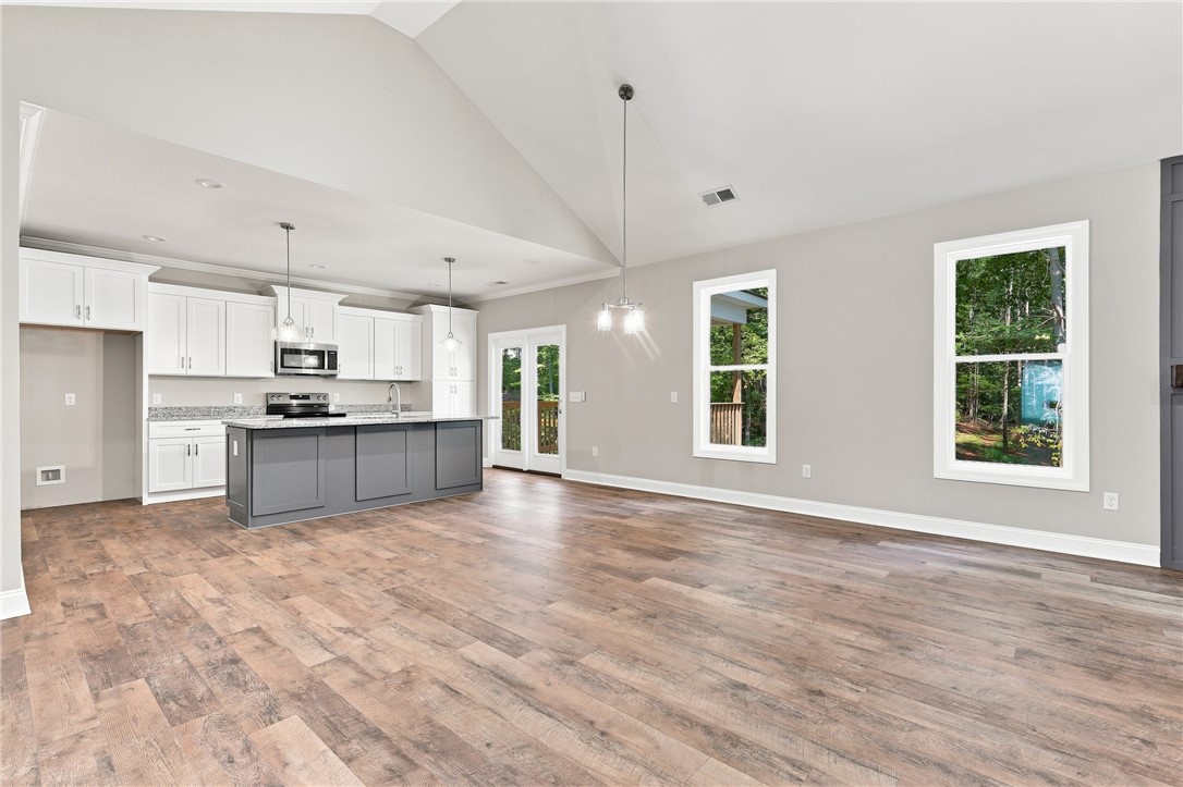 216 West Halfway Branch Road Walhalla, SC 29691 - Photo 9 of 41 Vaulted ceilings and wide-plank flooring define this airy open-concept living area and kitchen.