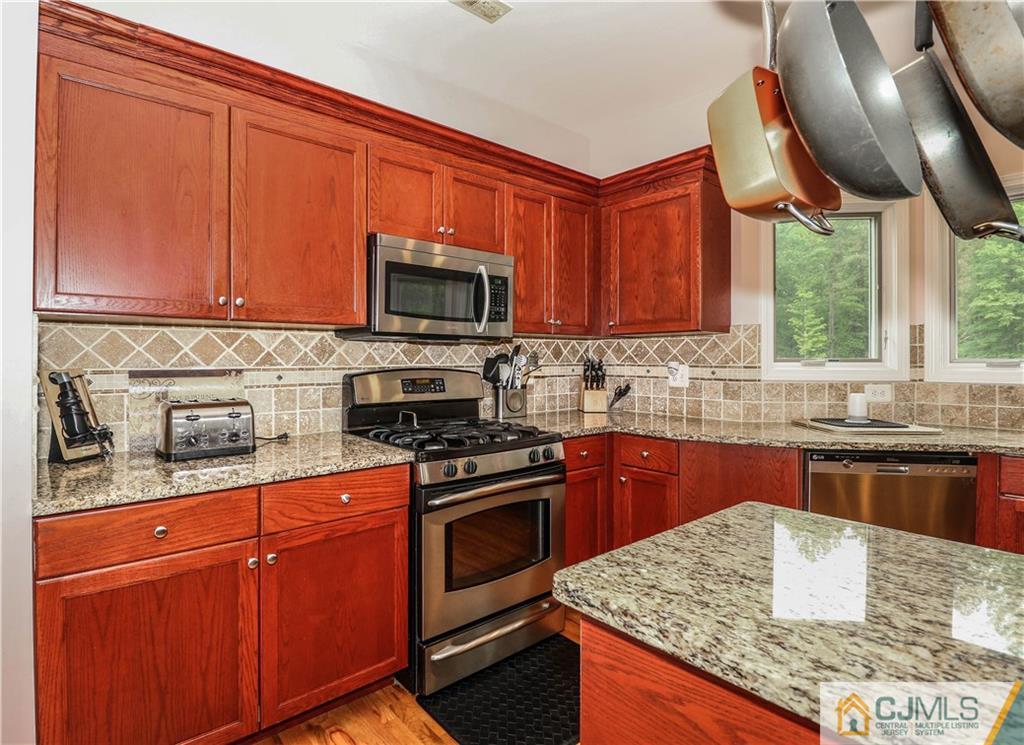 141 Westley Road Old Bridge, NJ 08857 - Photo 8 of 24 a kitchen with stainless steel appliances granite countertop wooden cabinets a stove top oven a sink and dishwasher