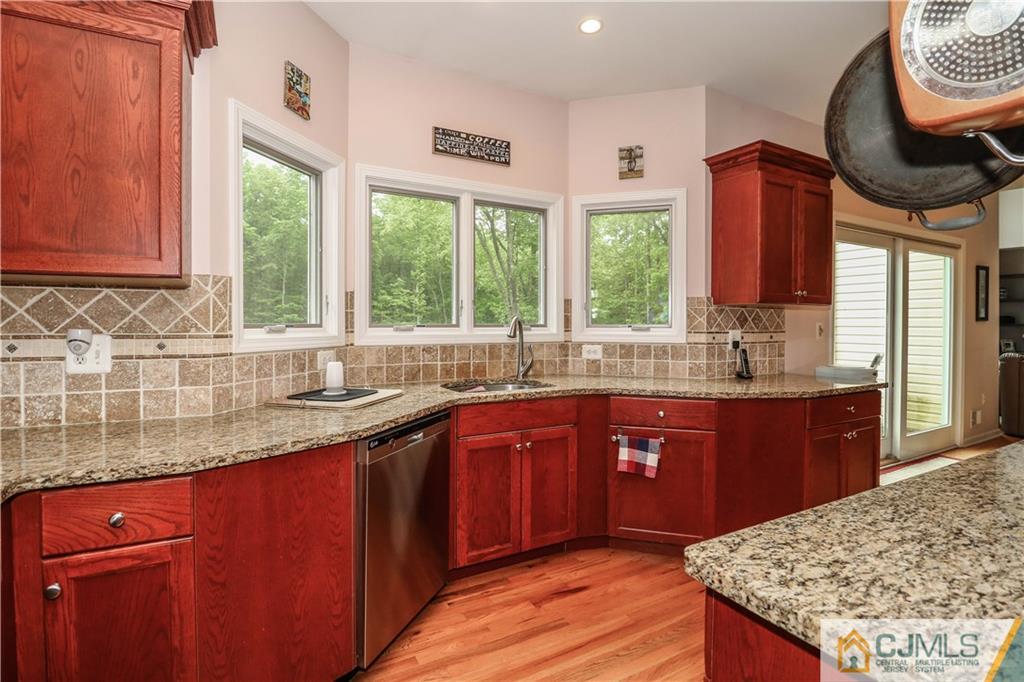 141 Westley Road Old Bridge, NJ 08857 - Photo 9 of 24 a kitchen with stainless steel appliances granite countertop wooden cabinets a sink and a large window
