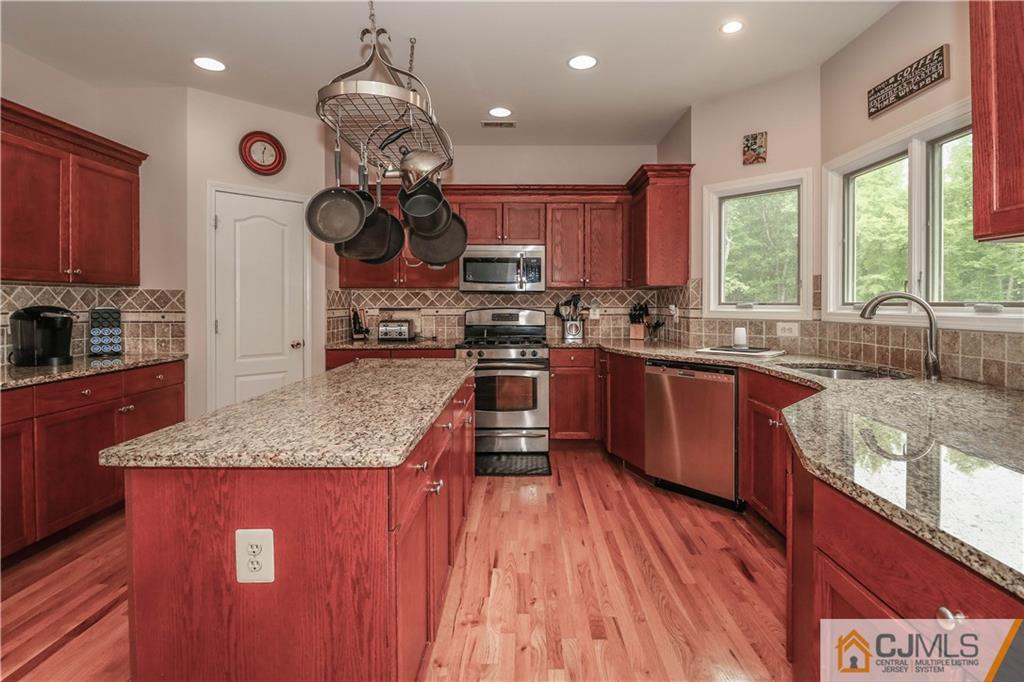 141 Westley Road Old Bridge, NJ 08857 - Photo 10 of 24 a kitchen with stainless steel appliances granite countertop a sink a stove and a wooden floors