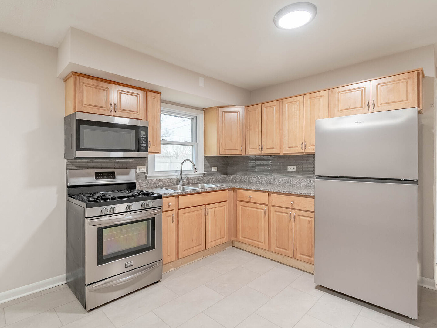 18331 Hickory Street Lansing, IL 60438 - Photo 3 of 12 a kitchen with granite countertop white cabinets white stainless steel appliances and wooden floors