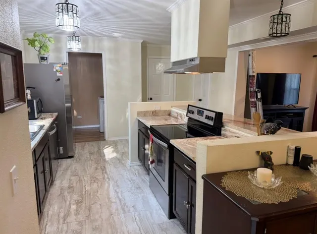 a kitchen that has a sink a stove and a table