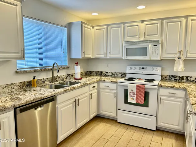 a kitchen with stainless steel appliances granite countertop a sink stove and cabinets
