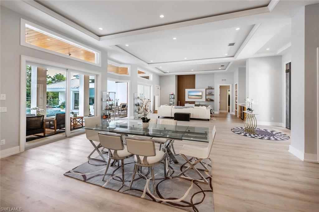 9240 The Lane Naples, FL 34109 - Photo 13 of 42 a view of a dining room with furniture wooden floor and a chandelier