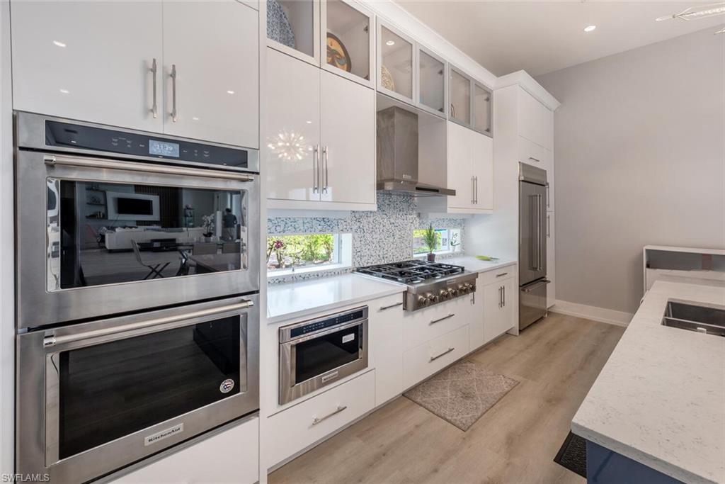 9240 The Lane Naples, FL 34109 - Photo 14 of 42 a kitchen with stainless steel appliances white cabinets and a stove