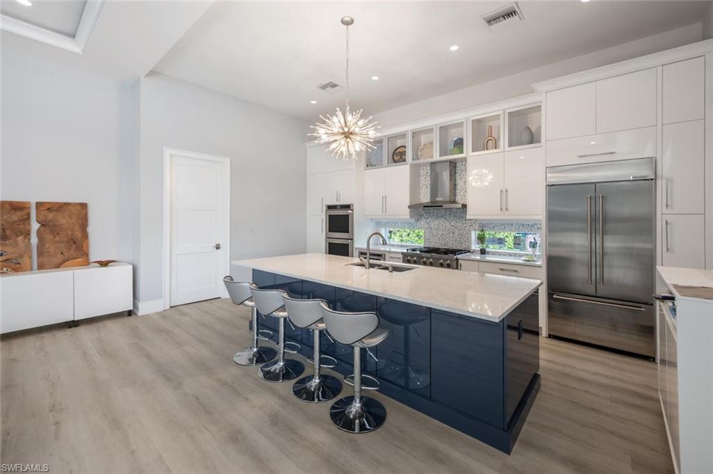 9240 The Lane Naples, FL 34109 - Photo 16 of 42 a kitchen with kitchen island a dining table chairs stainless steel appliances and cabinets