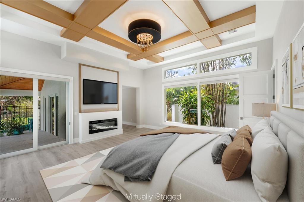9240 The Lane Naples, FL 34109 - Photo 18 of 42 a bedroom with a bed and a large window