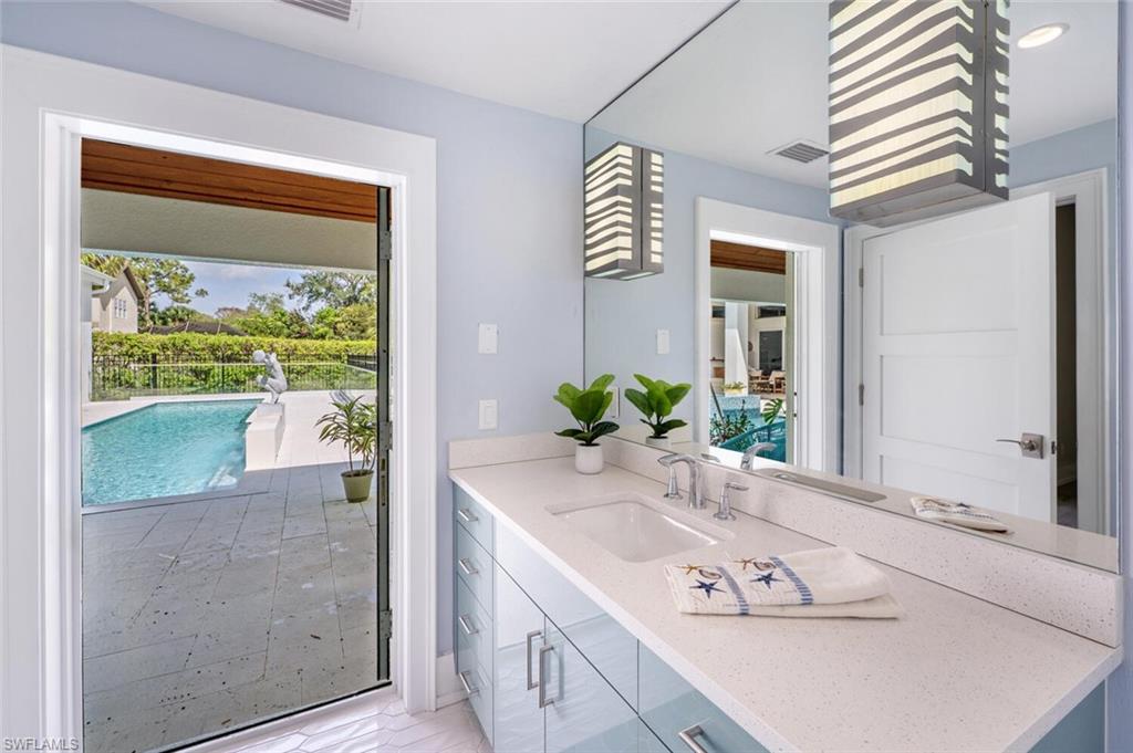 9240 The Lane Naples, FL 34109 - Photo 21 of 42 a bathroom with a tub sink and mirror