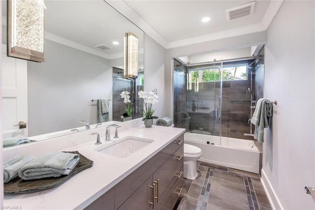 9240 The Lane Naples, FL 34109 - Photo 37 of 42 a bathroom with a sink a toilet and shower