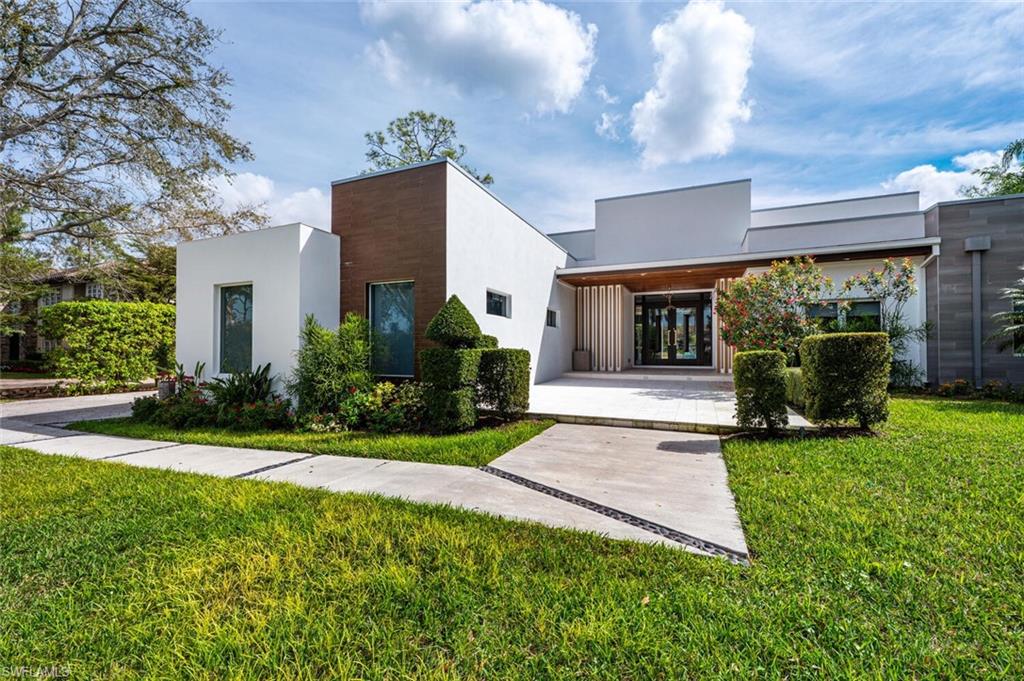 9240 The Lane Naples, FL 34109 - Photo 40 of 42 a front view of a house with garden