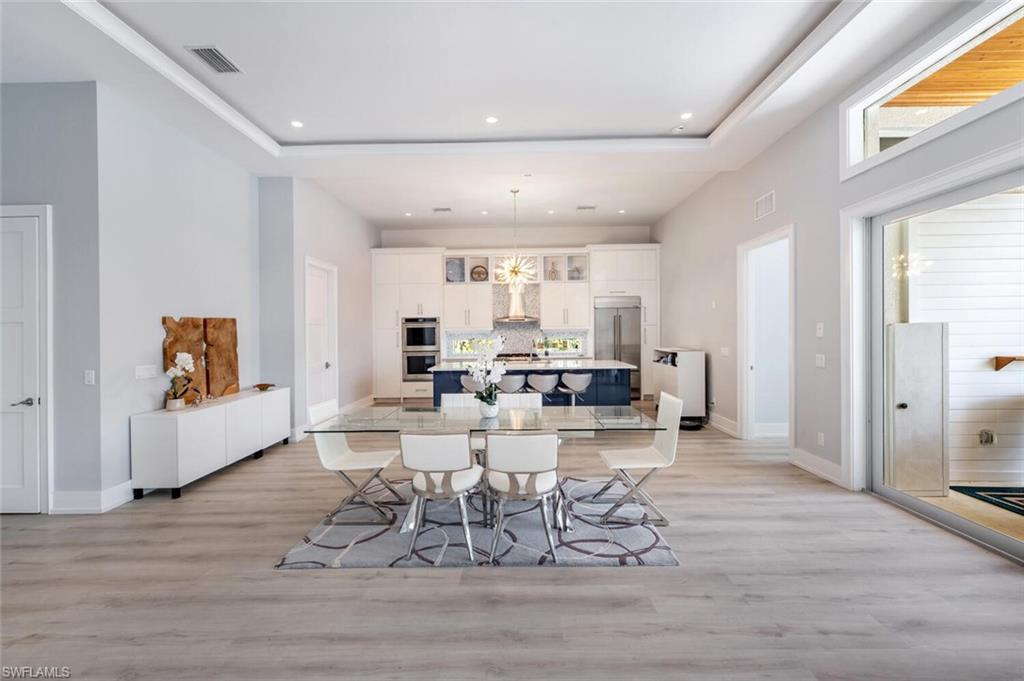 9240 The Lane Naples, FL 34109 - Photo 7 of 42 a dining room with furniture and wooden floor