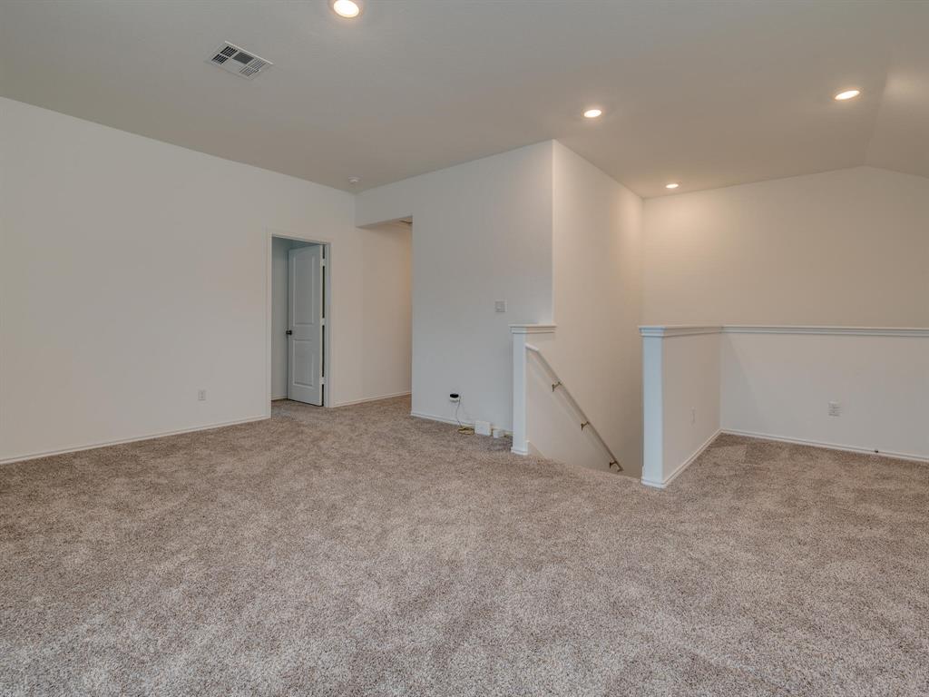 1208 Sweetspire Street Leander, TX 78641 - Photo 22 of 36 Spacious carpeted room featuring recessed lighting, a white painted door with black hardware, and a staircase with a white railing
