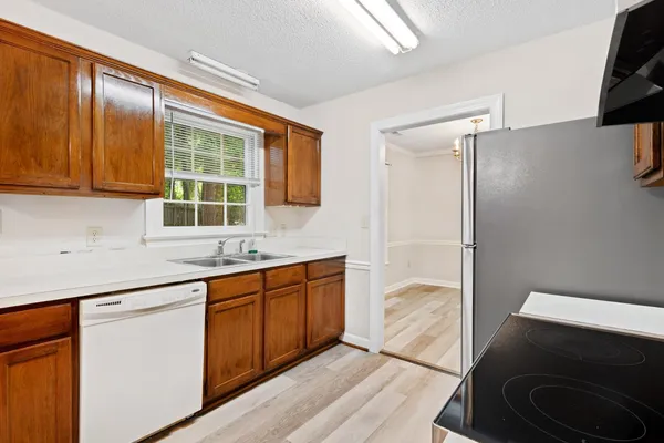 a kitchen with granite countertop a sink stainless steel appliances and cabinets