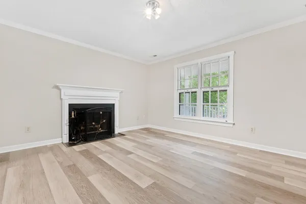a view of an empty room with a window and a fireplace