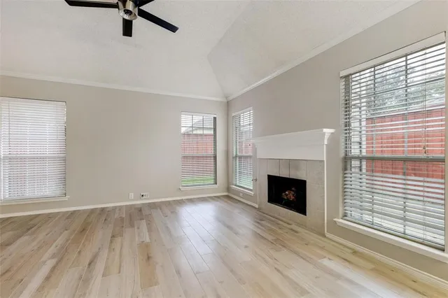 wooden floor fireplace and windows in an empty room
