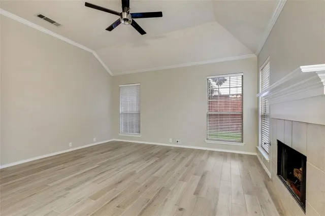 a view of empty room with wooden floor and fireplace