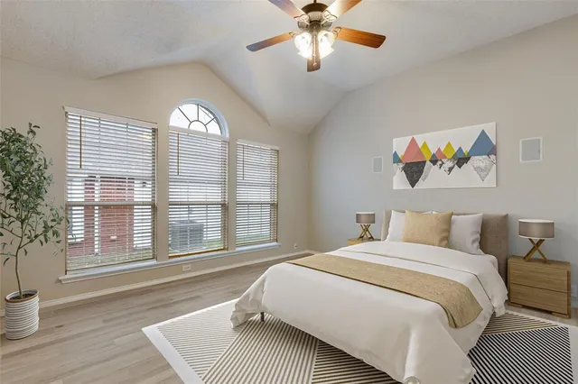 a spacious bedroom with a bed and a large window