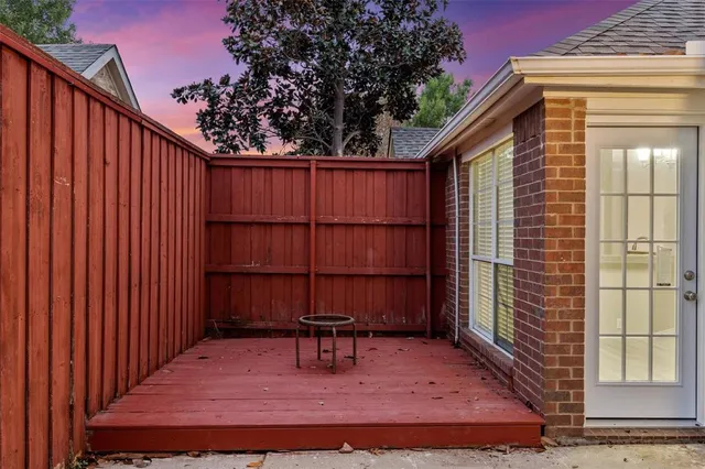 a view of backyard with wooden fence and large trees