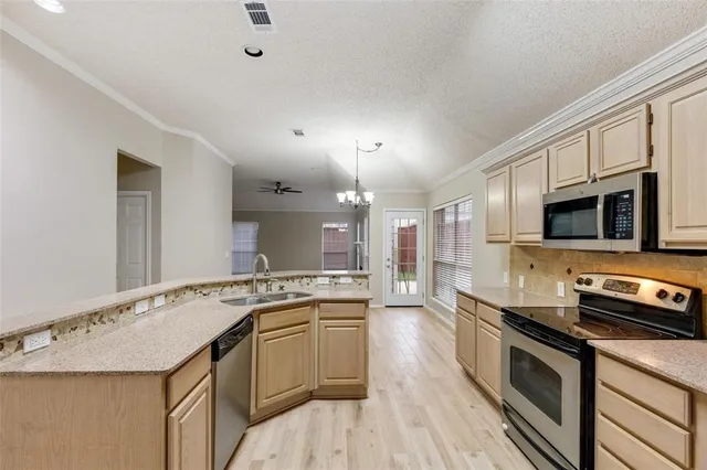 a kitchen with stainless steel appliances granite countertop a sink stove and microwave