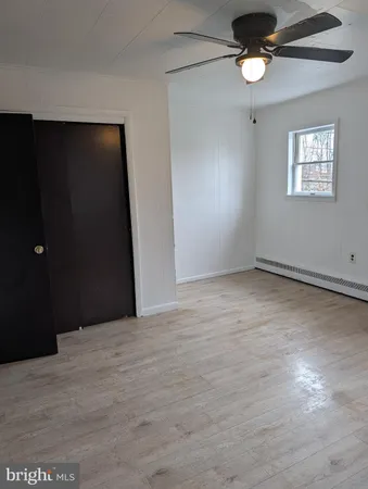 an empty room with windows and fan