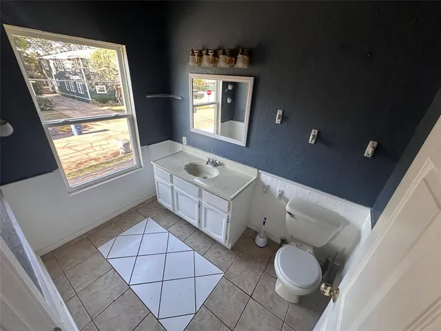 a bathroom with a sink toilet and window