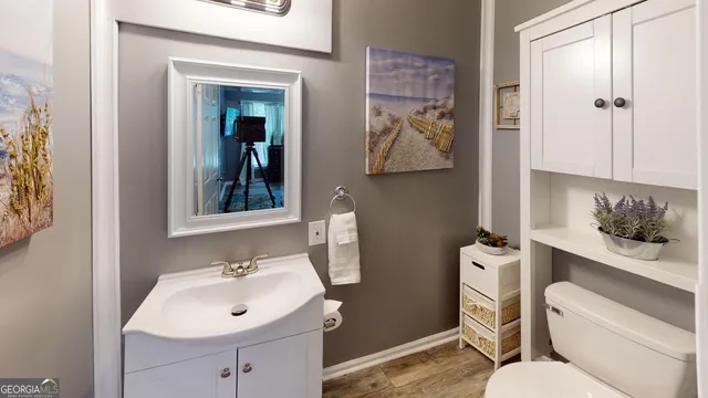 a bathroom with a sink mirror vanity and toilet
