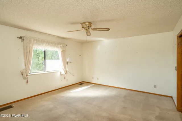 a view of an empty room with wooden floor and a fireplace