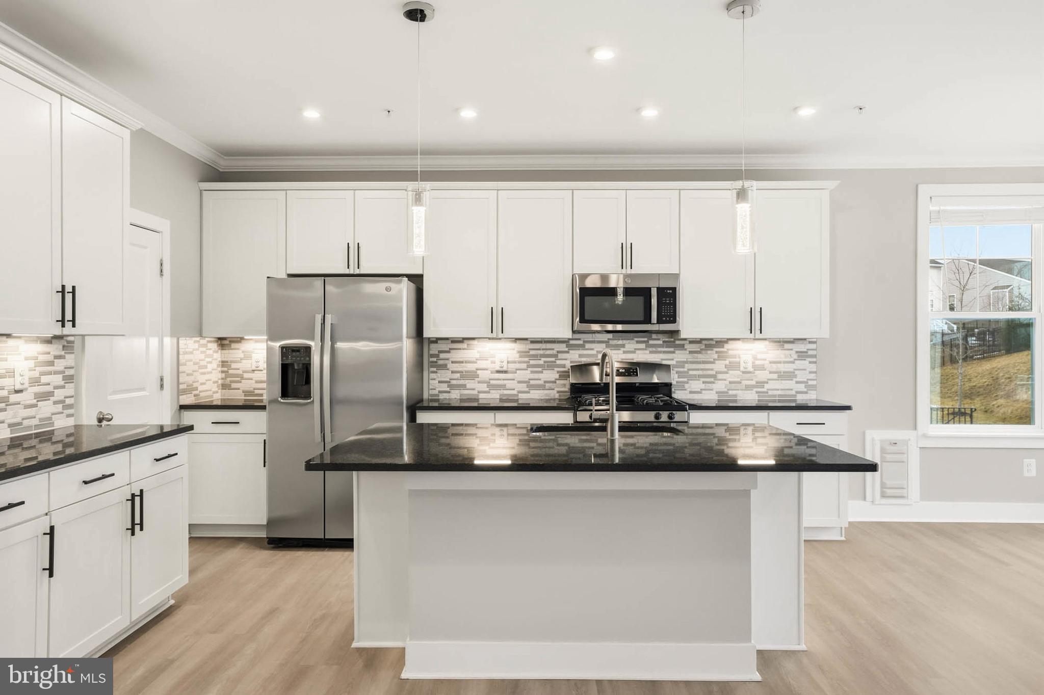 2305 Connor Circle Mount Airy, MD 21771 - Photo 6 of 44 a kitchen with stainless steel appliances granite countertop a refrigerator a stove a sink and white cabinets with wooden floor