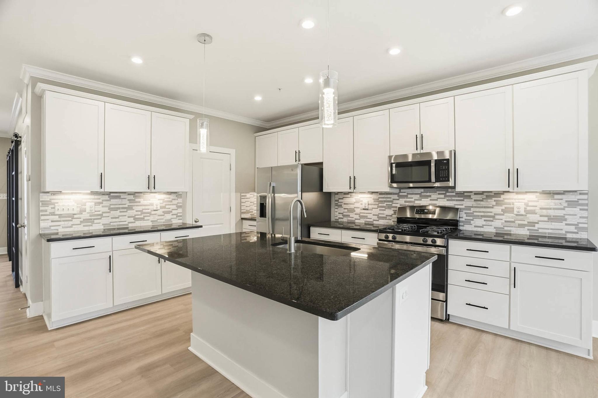 2305 Connor Circle Mount Airy, MD 21771 - Photo 7 of 44 a kitchen with kitchen island granite countertop a stove sink and microwave