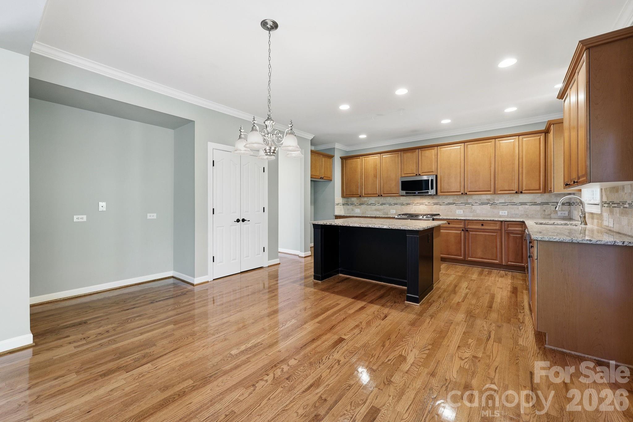 3308 Grandeur Road Charlotte, NC 28269 - Photo 12 of 45 a large kitchen with stainless steel appliances granite countertop a stove and a wooden floors