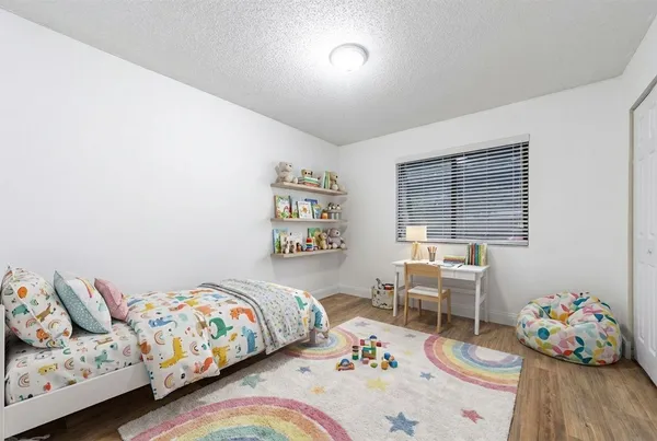 a bedroom with bed and a wooden floor
