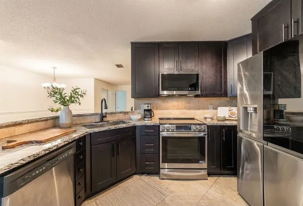 a kitchen with stainless steel appliances granite countertop a stove and a sink