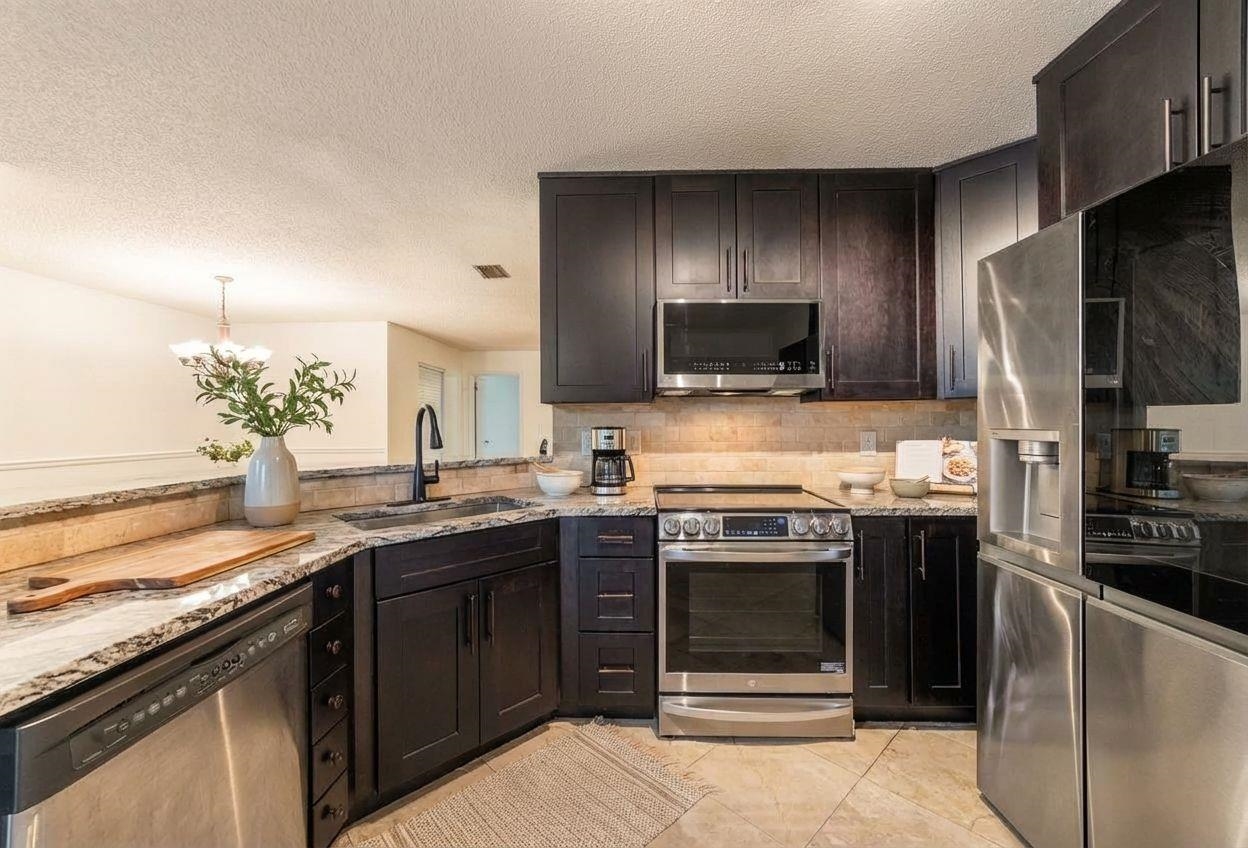 111 Lobelia Road St. Augustine, FL 32086 - Photo 4 of 16 a kitchen with stainless steel appliances granite countertop a stove and a sink